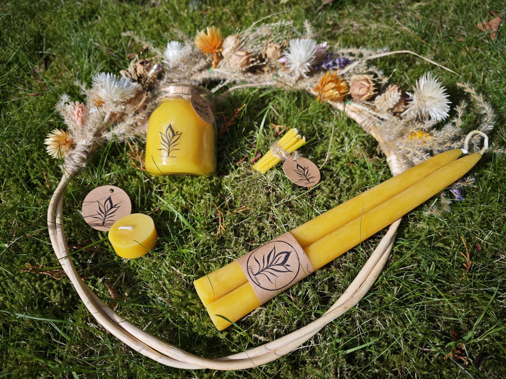 Bijenwas kaars op een doorzichtig bord met een crèmekleurig servet op een houten oppervlak.