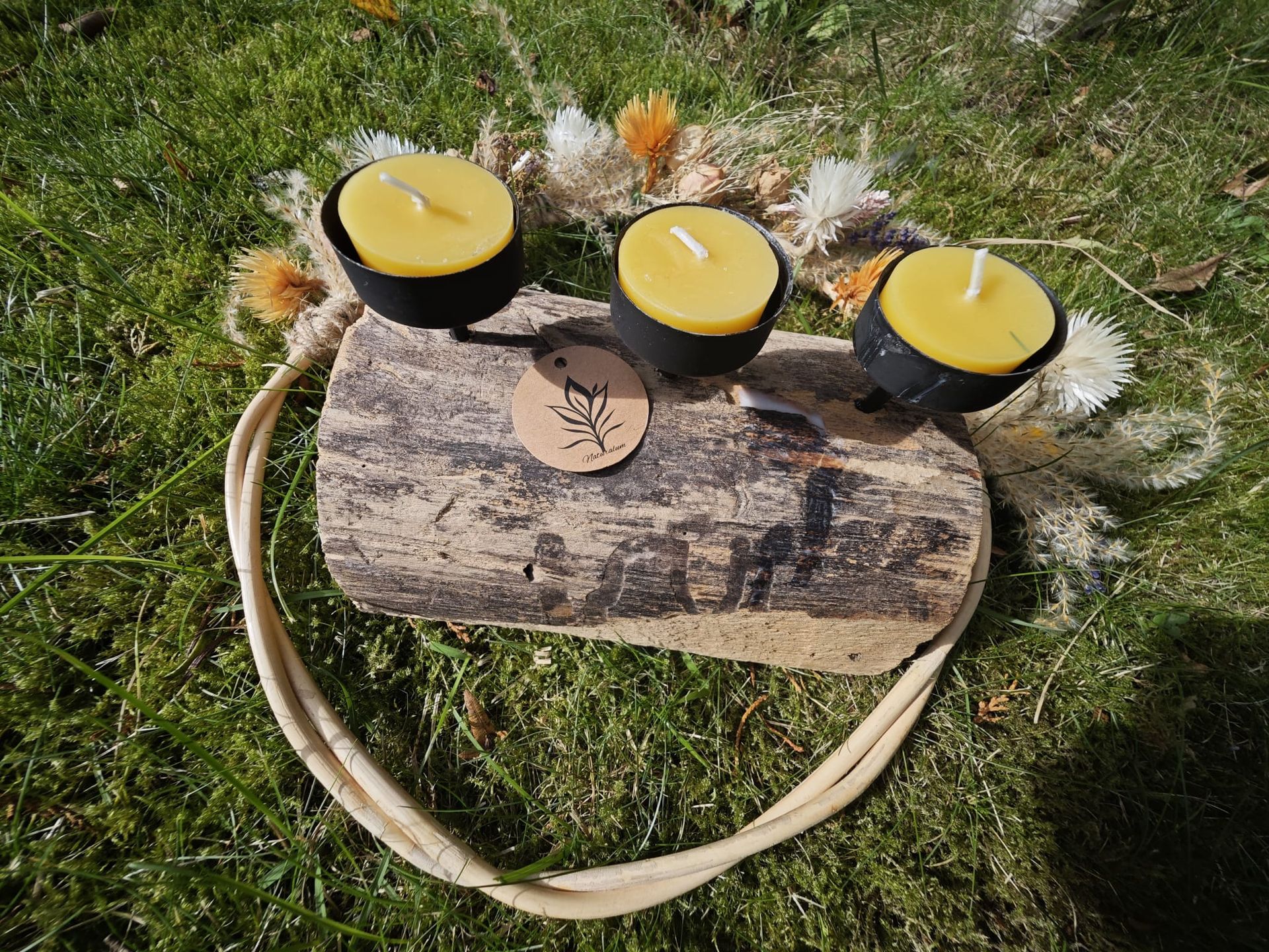 Lachend meisje met lang haar aan een tafel, verjaardagstaart met brandende bijenwas kaarsjes, kaarsen aan beide kanten.