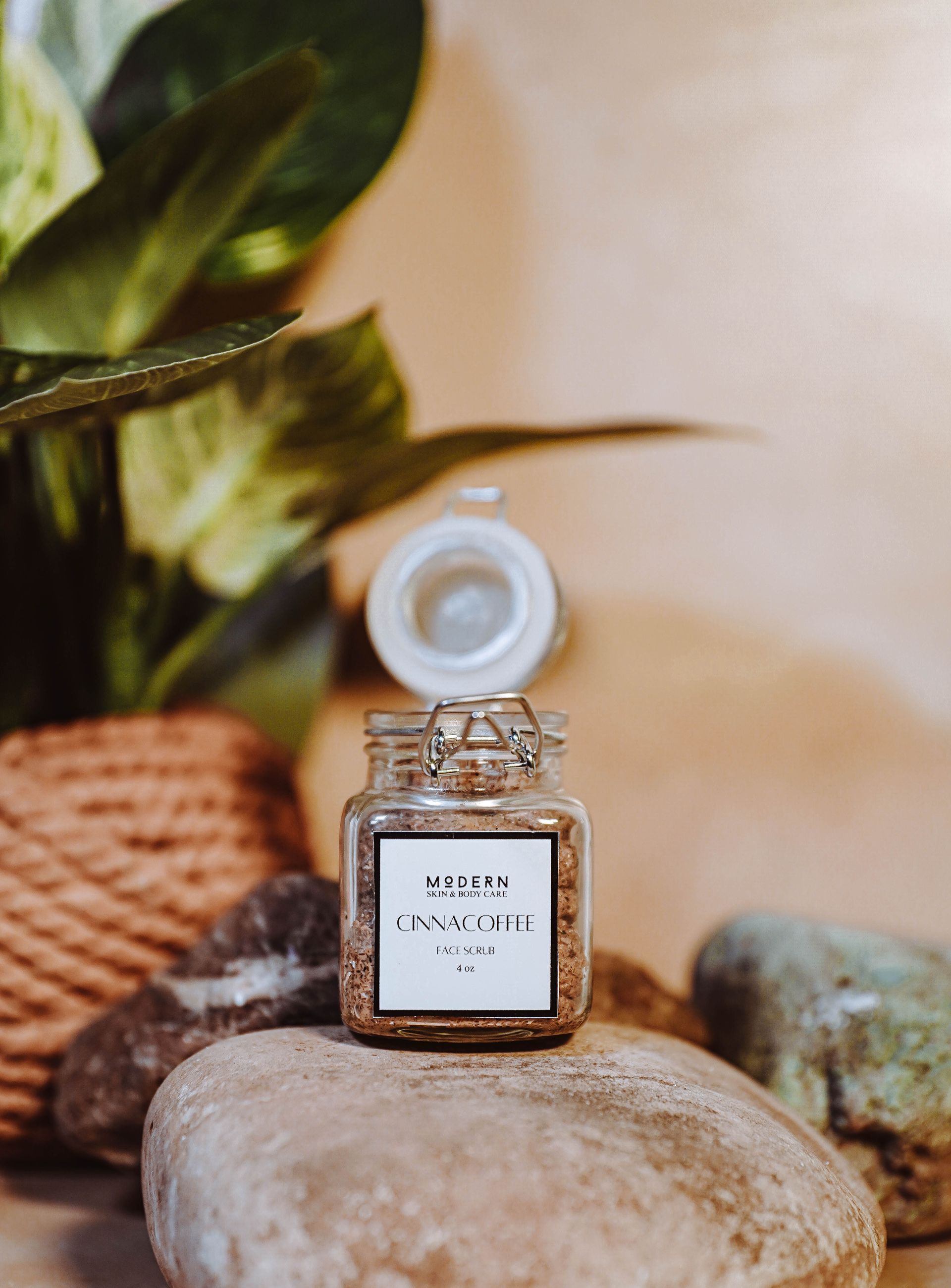 Jar with open lid with rich foaming coffee face scrub inside