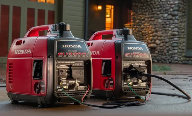 Two honda generators are sitting next to each other on the side of the road.