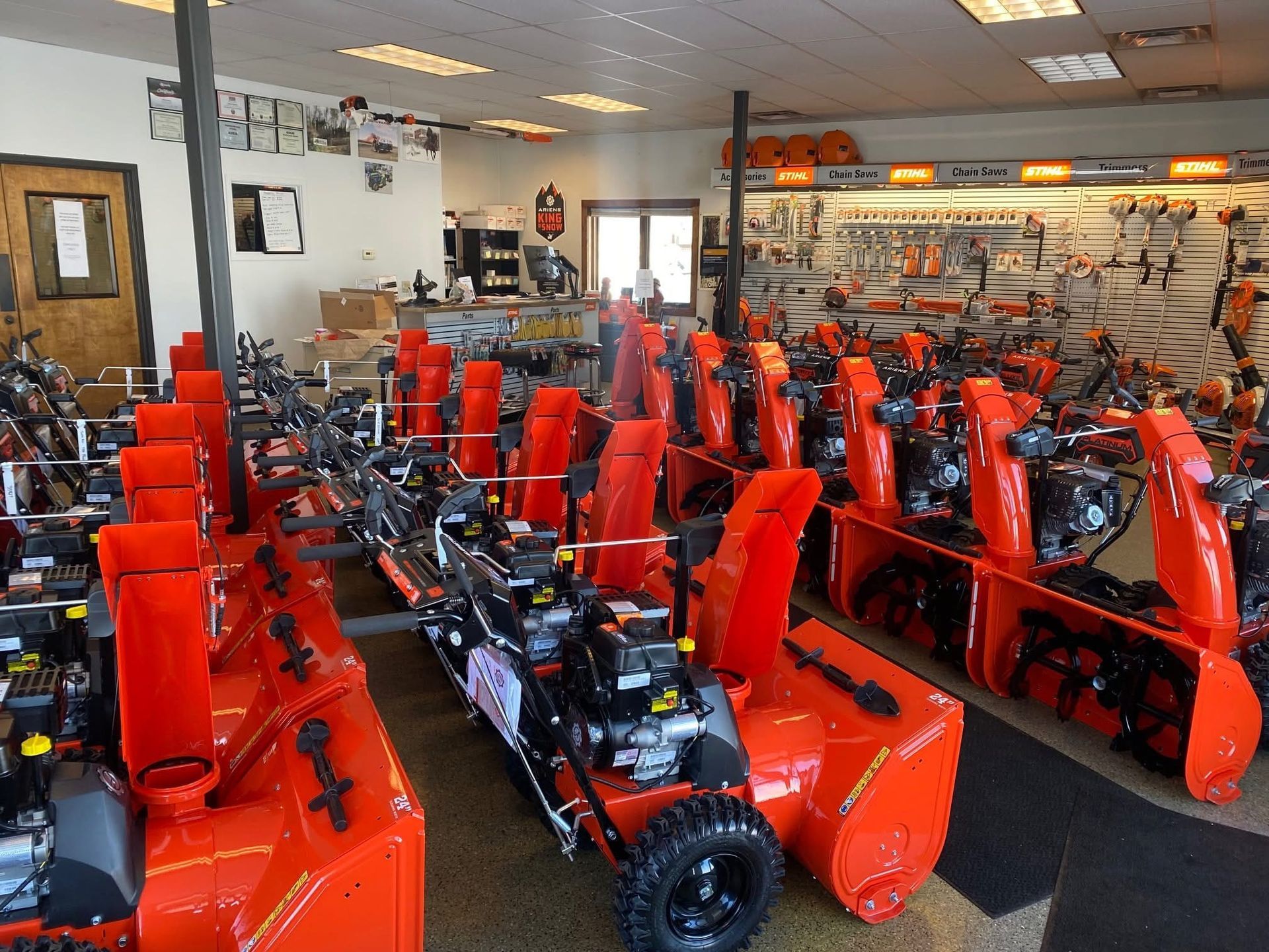 A store filled with lots of orange snow blowers