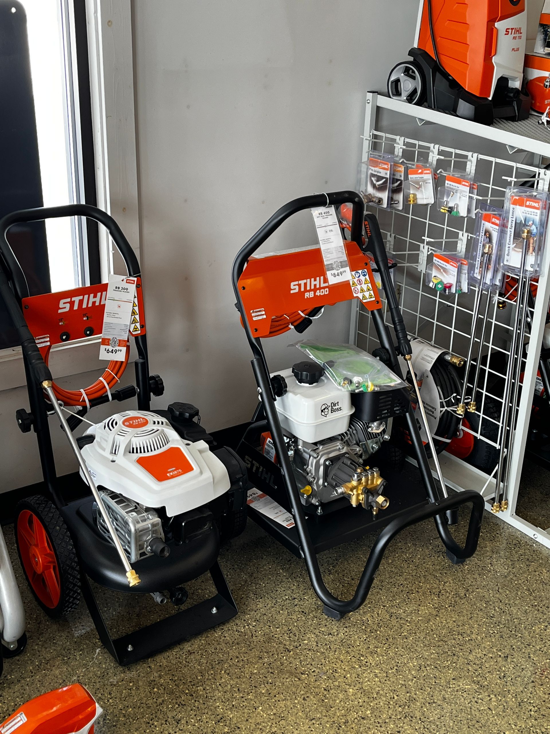 Two stihl pressure washers are sitting on the floor in a store.