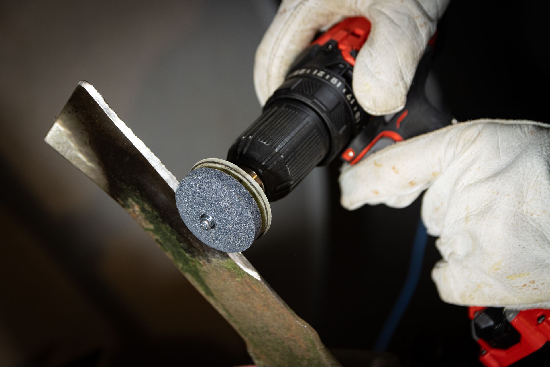 A person is using a drill to grind a piece of metal.