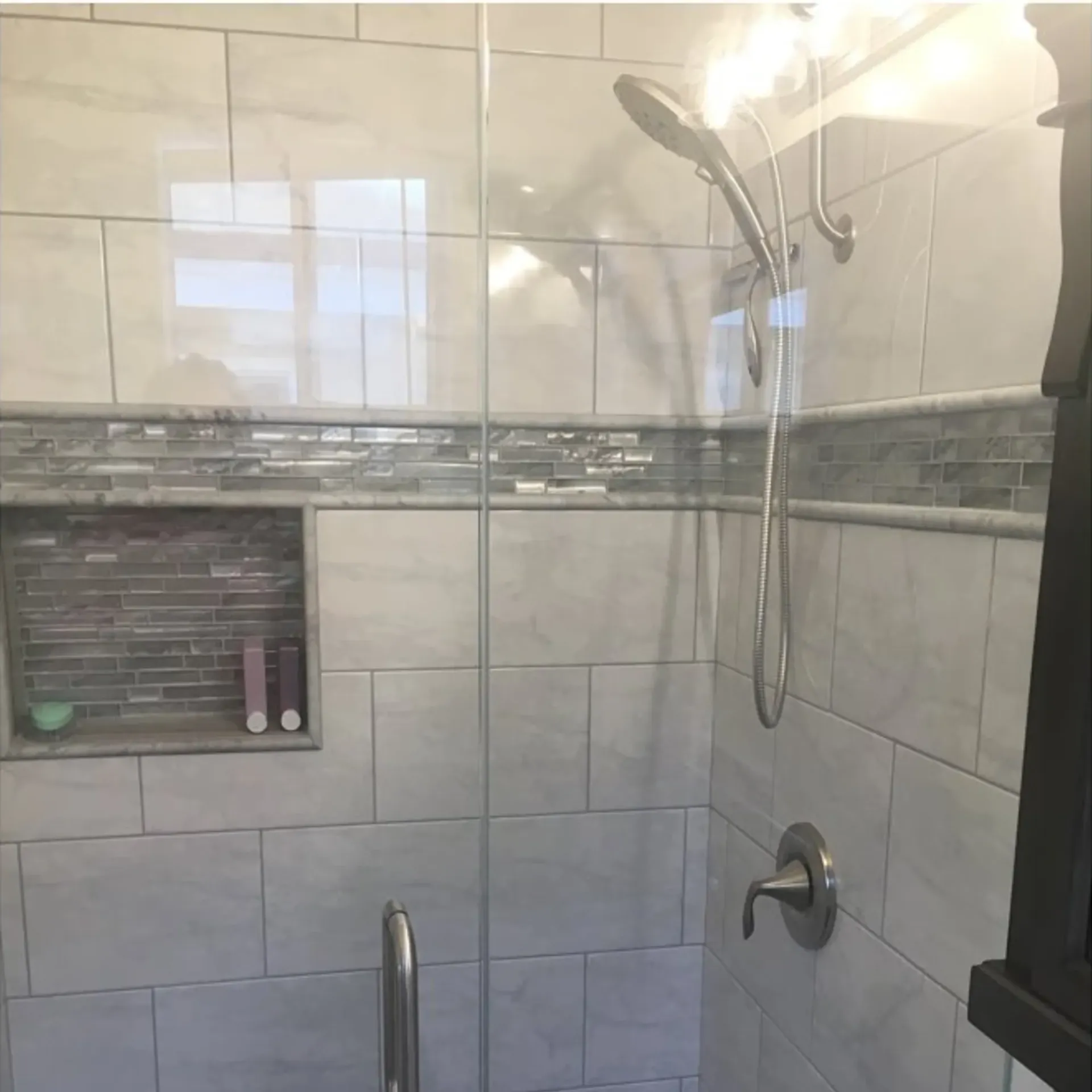 Ted & Bros Plumbing | shower with a glass door and a shower head
