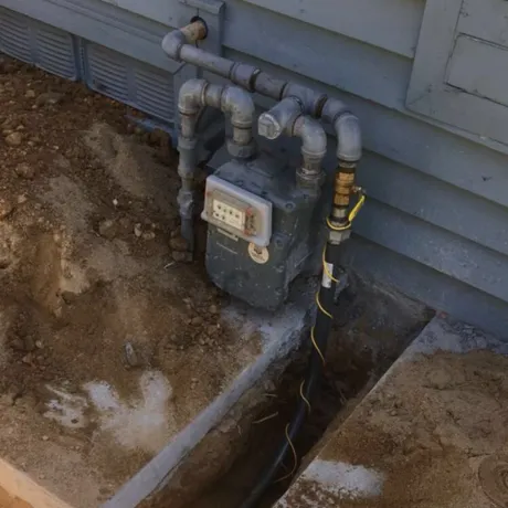 Ted & Bros Plumbing | gas meter is sitting on the side of a house