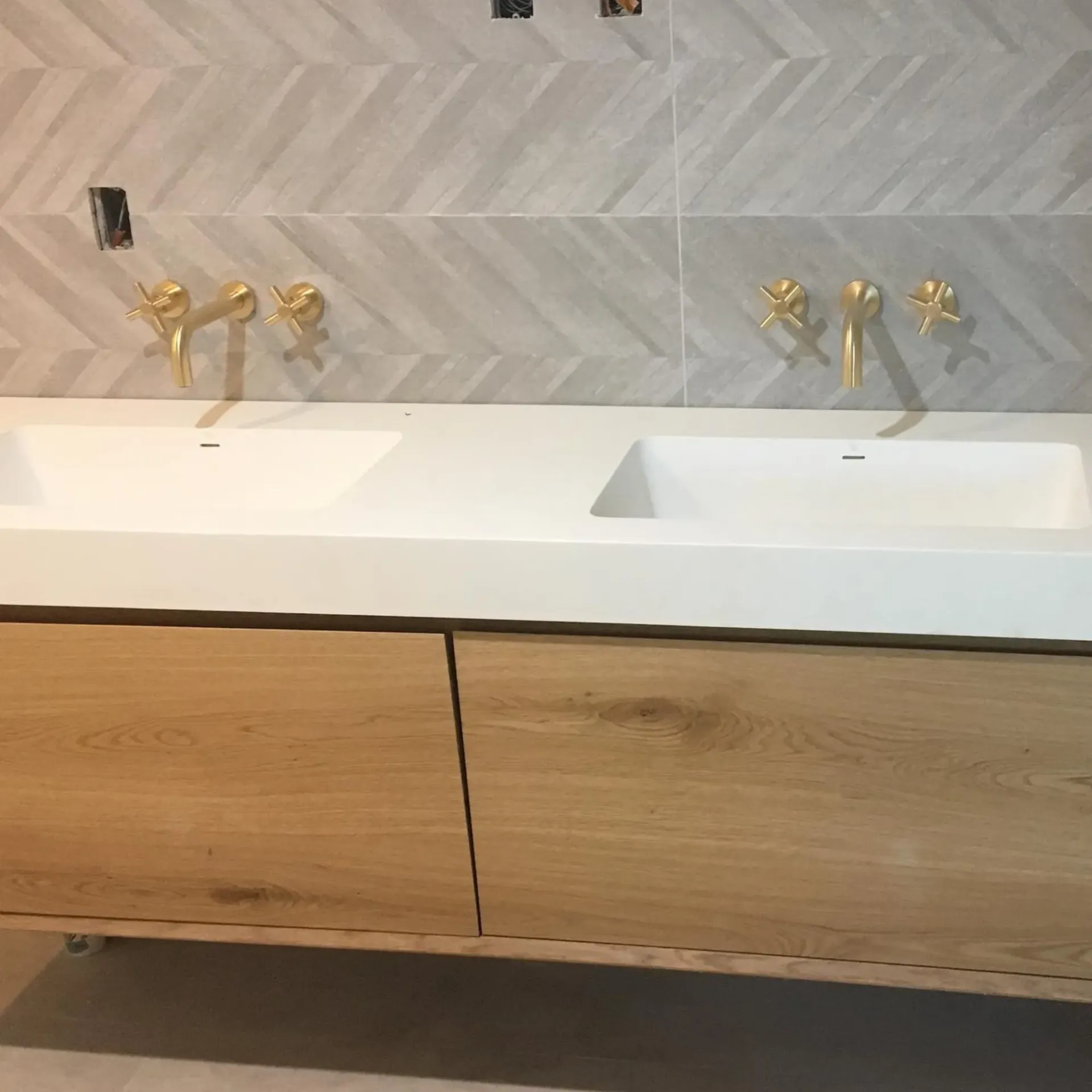 Ted & Bros Plumbing | bathroom with two sinks and gold faucets.