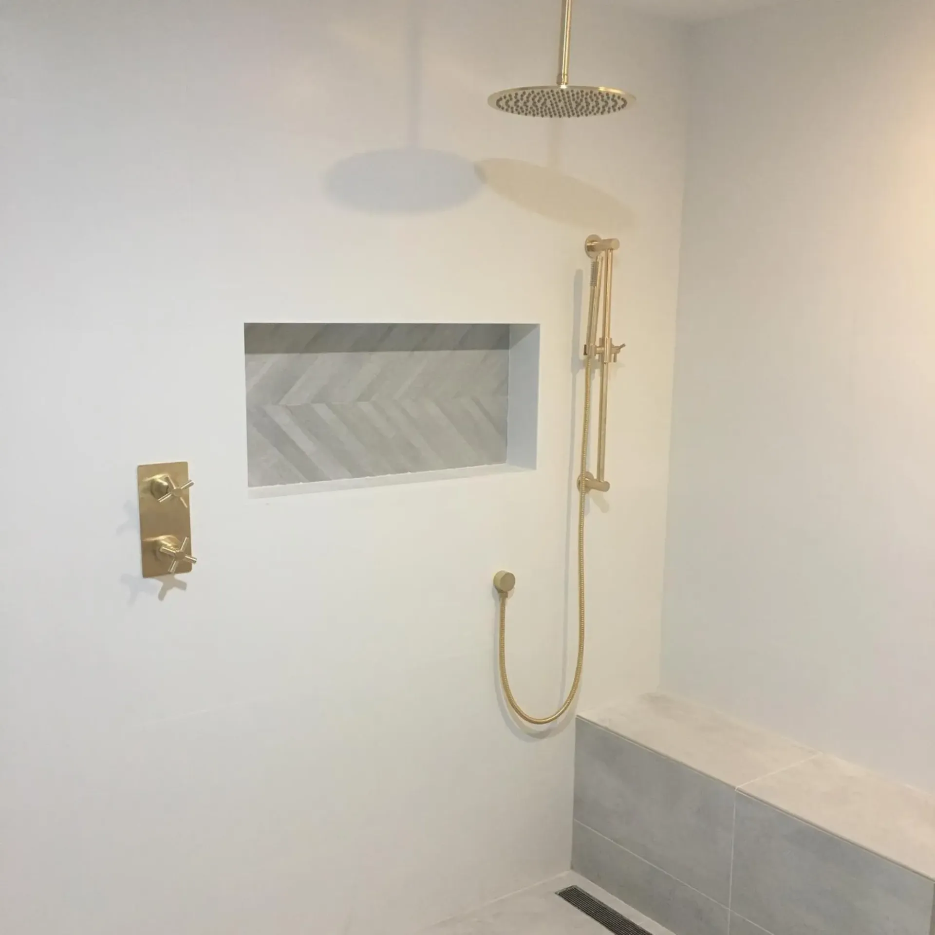 Ted & Bros Plumbing | bathroom with a shower head and a bench.