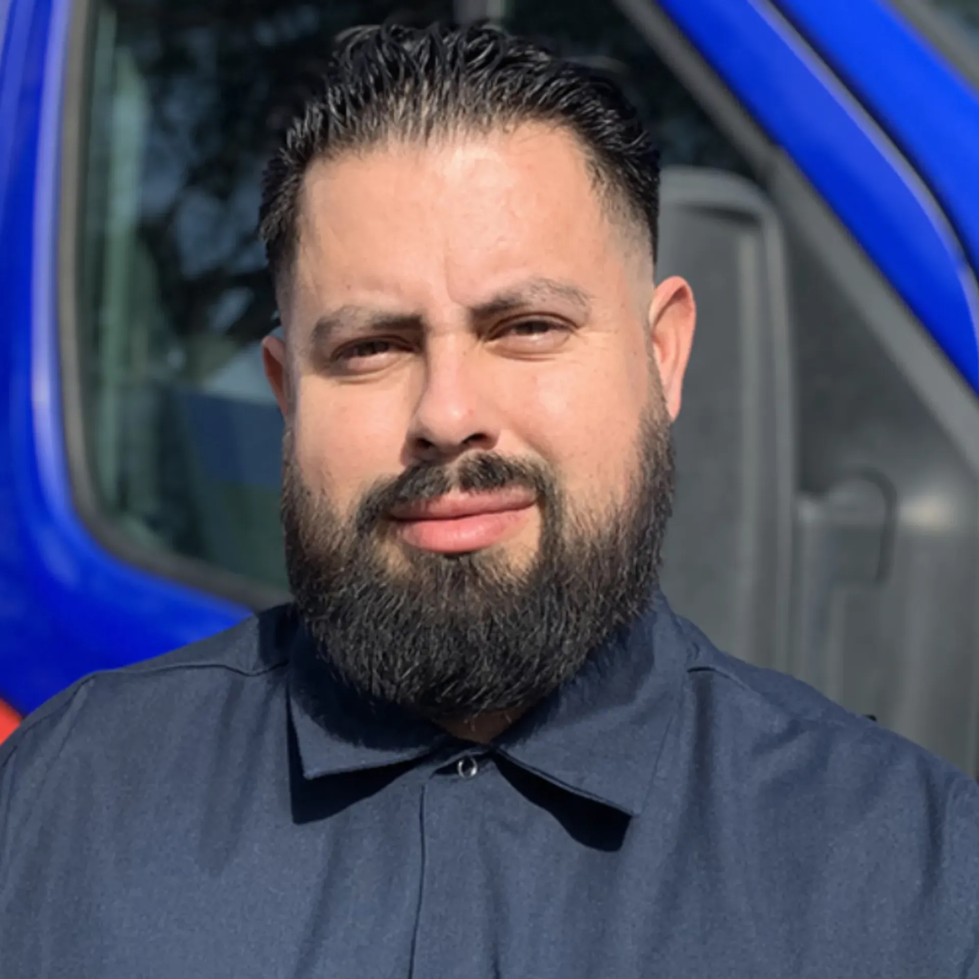 Ted & Bros Plumbing | man with a beard is standing in front of a blue van.
