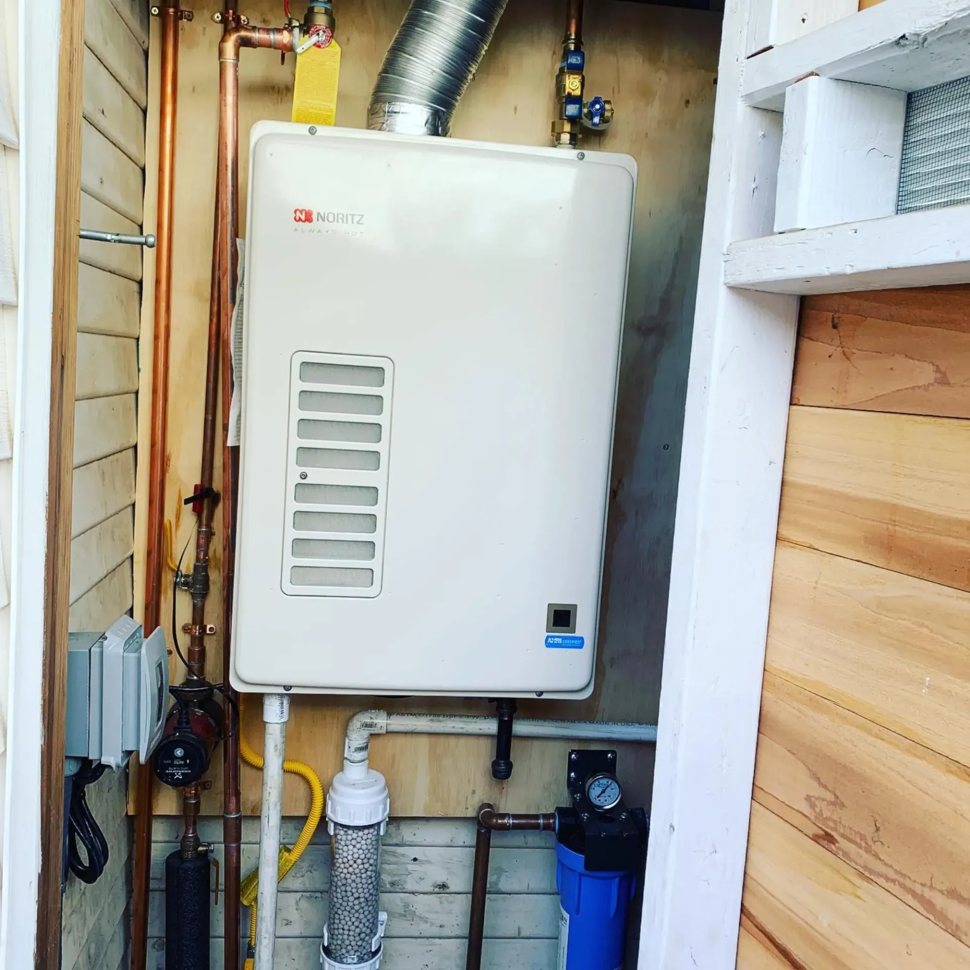 Ted & Bros Plumbing | white water heater is attached to a wooden wall