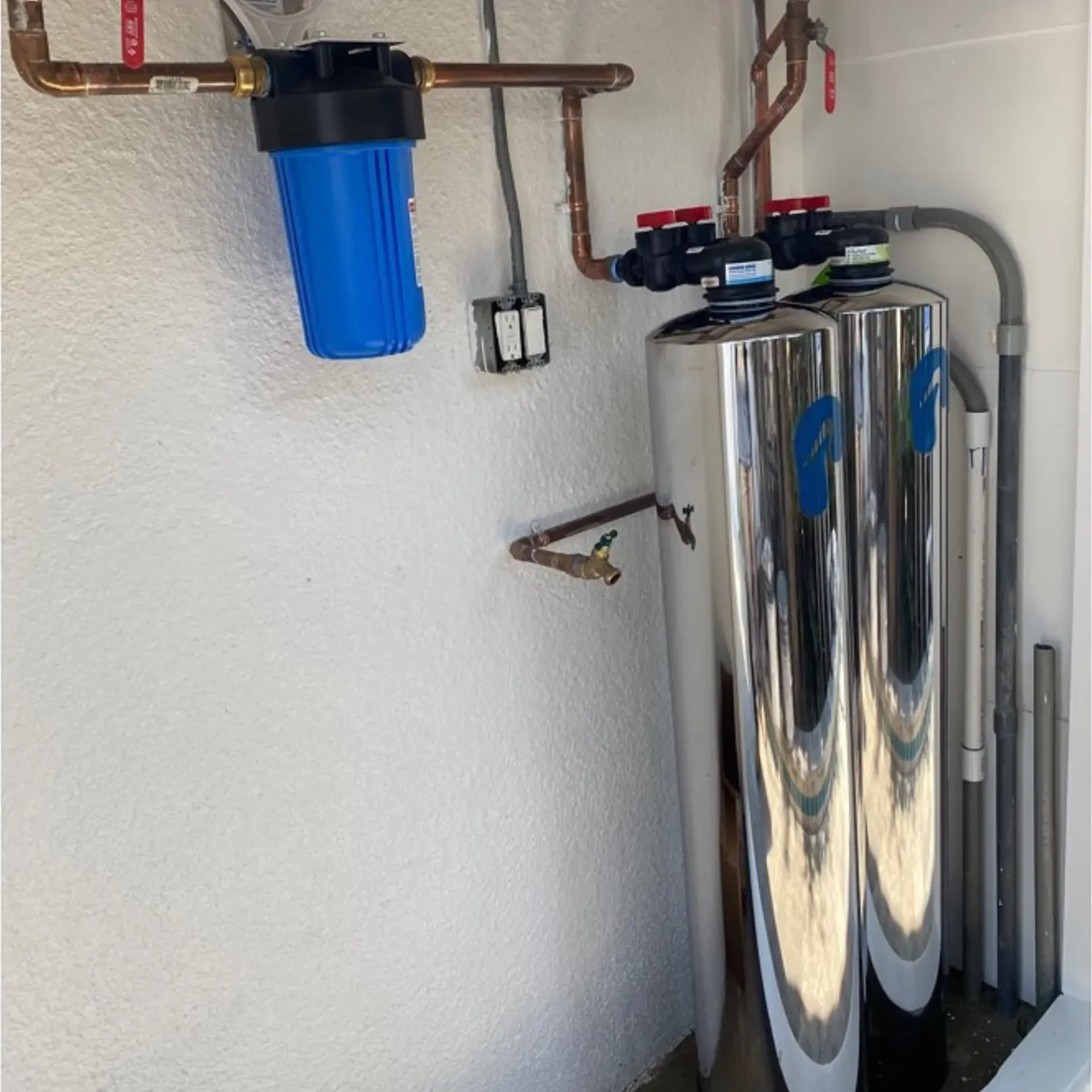 Ted & Bros Plumbing | blue water filter is attached to a white wall