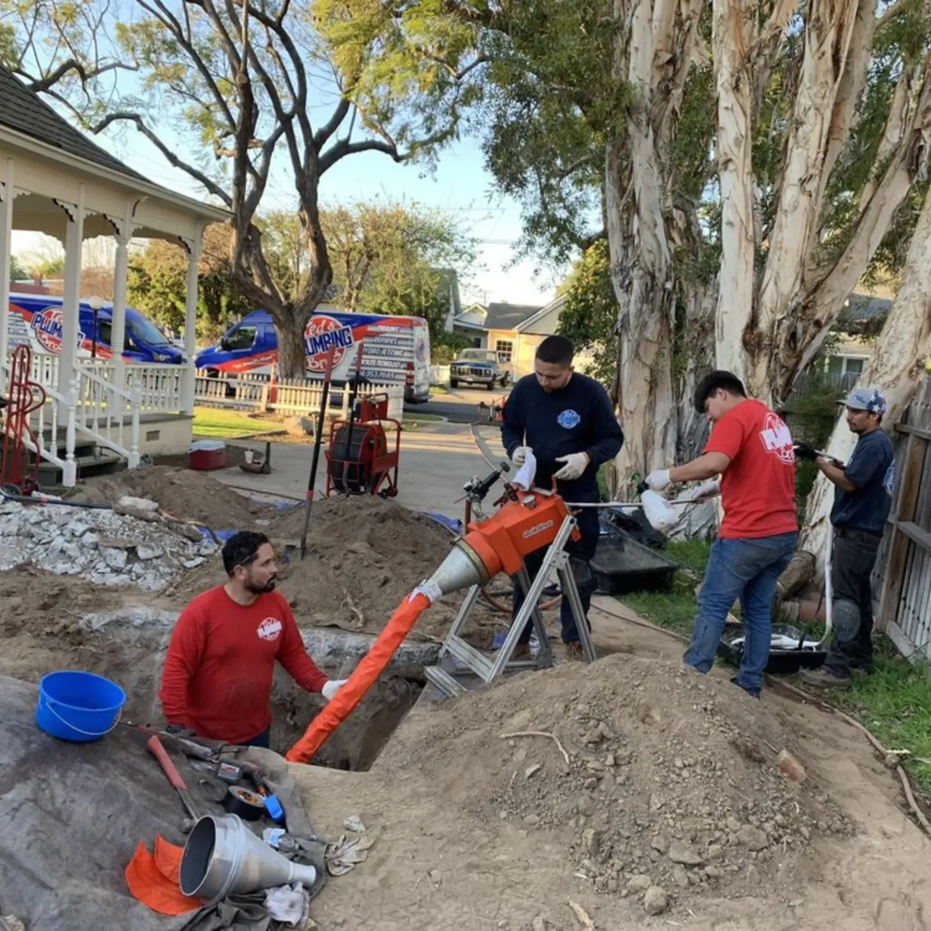Ted & Bros Plumbing | group of men are working on a construction site in front of a house.