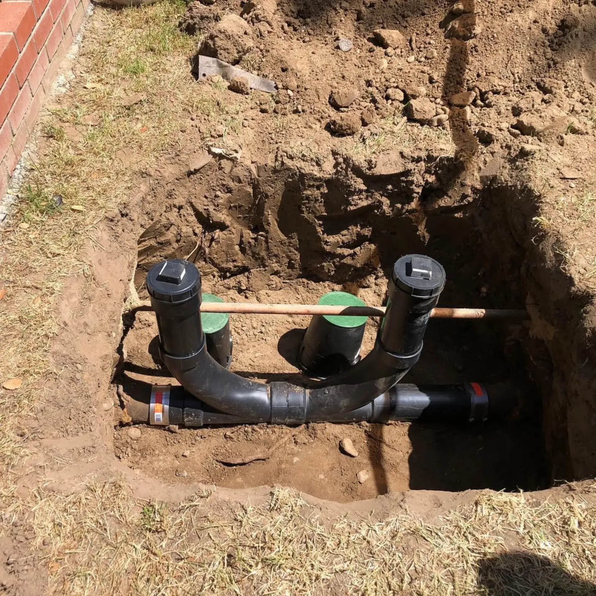 Ted & Bros Plumbing | drain pipe is being installed in a hole in the ground.