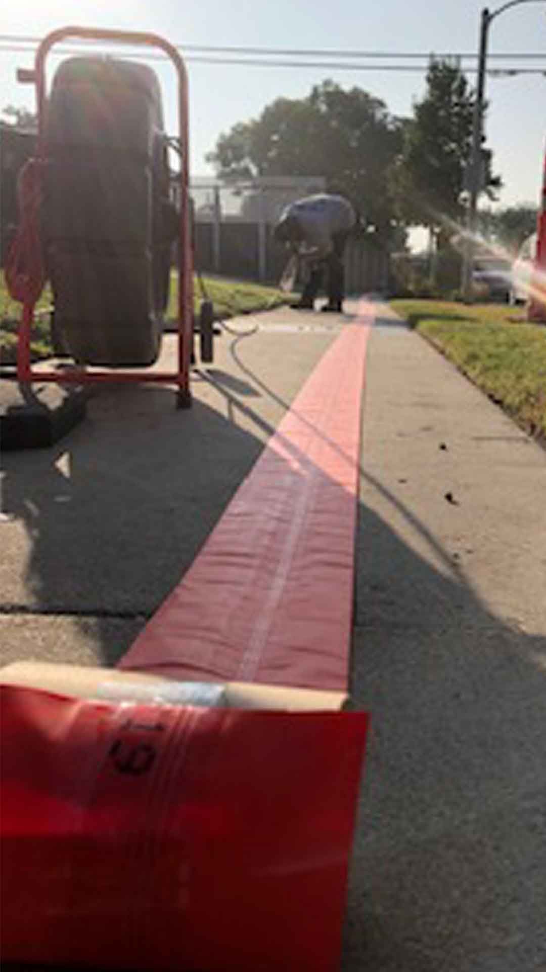 Ted & Bros Plumbing | man is standing on a sidewalk next to a red tape.