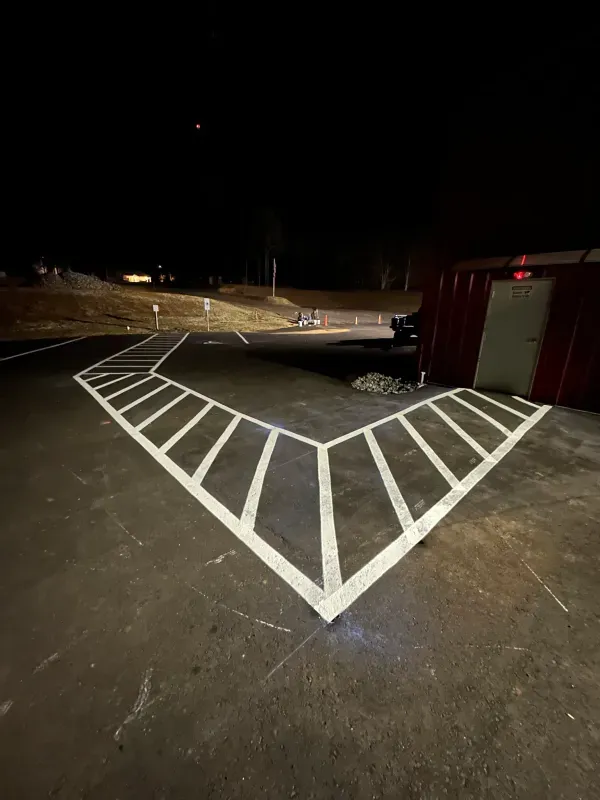 A parking lot with a handicapped parking space painted on it at night.