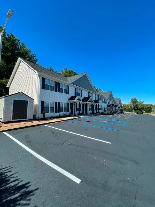 A row of houses with a parking lot in front of them