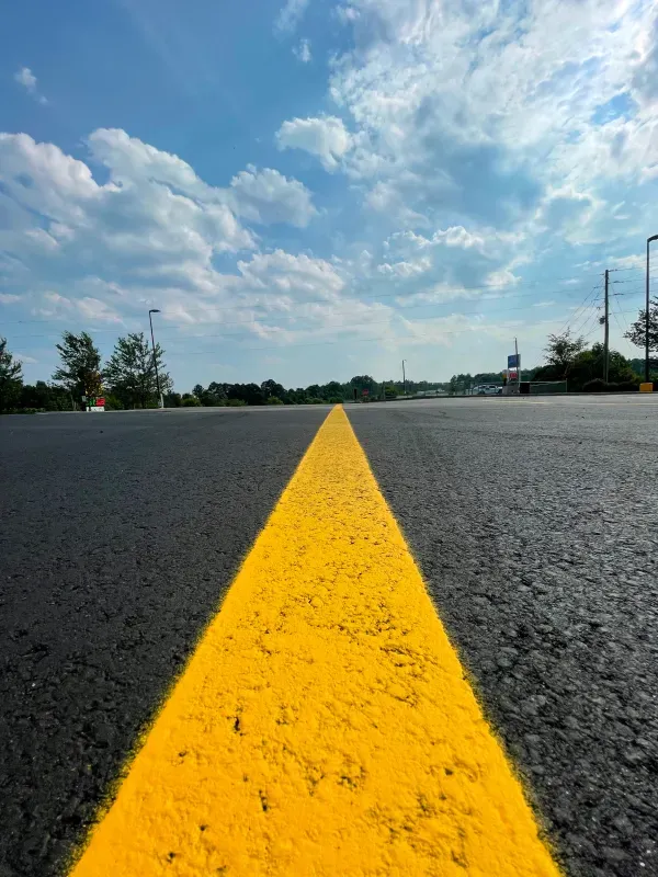A yellow line is painted on the side of a road.