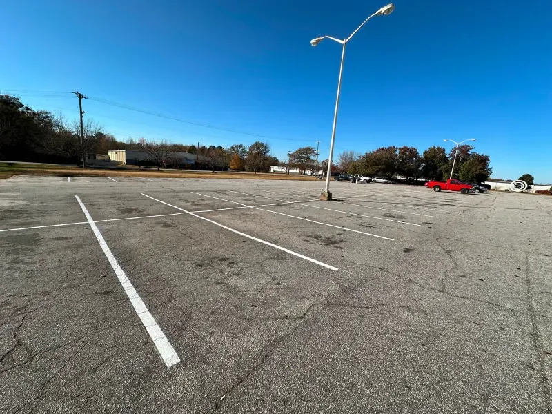 An empty parking lot with a red truck parked in it.