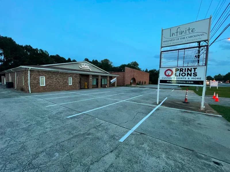 A brick building with a parking lot in front of it and a sign that says print lions.