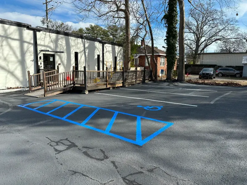 A handicapped parking spot is painted blue in a parking lot.