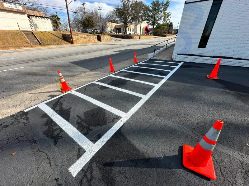 A row of orange and white traffic cones on the side of a road.