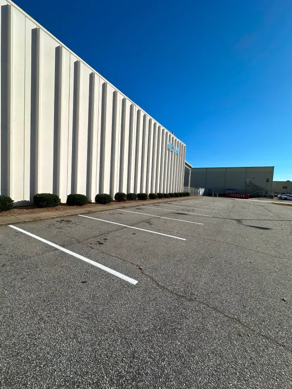 A large white building with a parking lot in front of it.