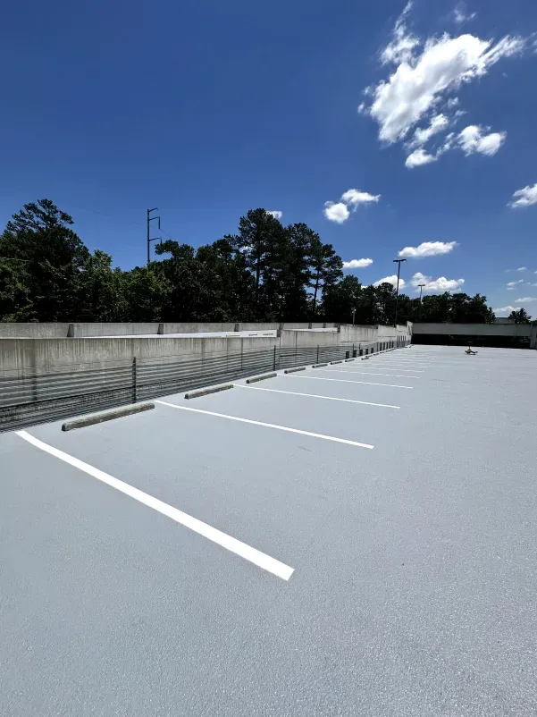 An empty parking lot with a blue sky in the background