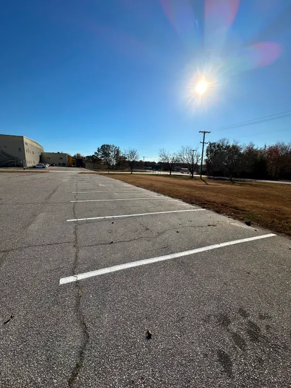 The sun is shining brightly over an empty parking lot