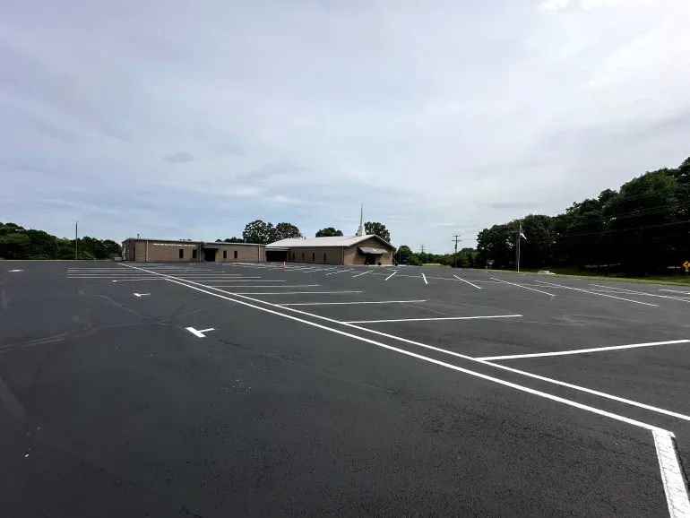 An empty parking lot with a church in the background.