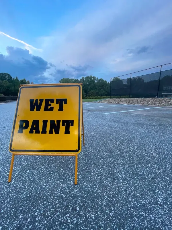 A yellow sign that says wet paint on it