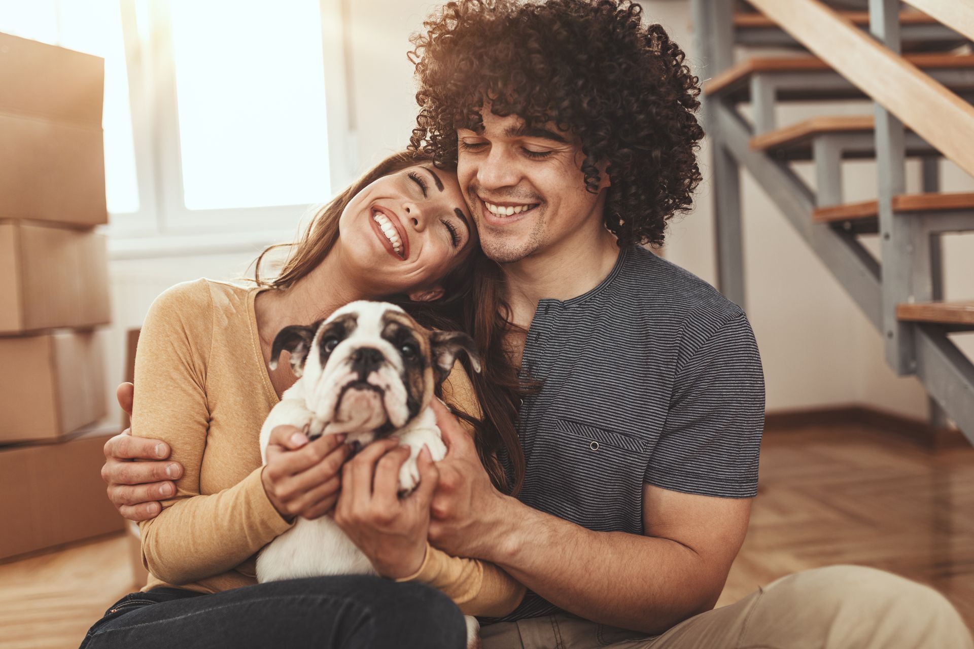 a man and a woman are sitting on the floor holding a puppy