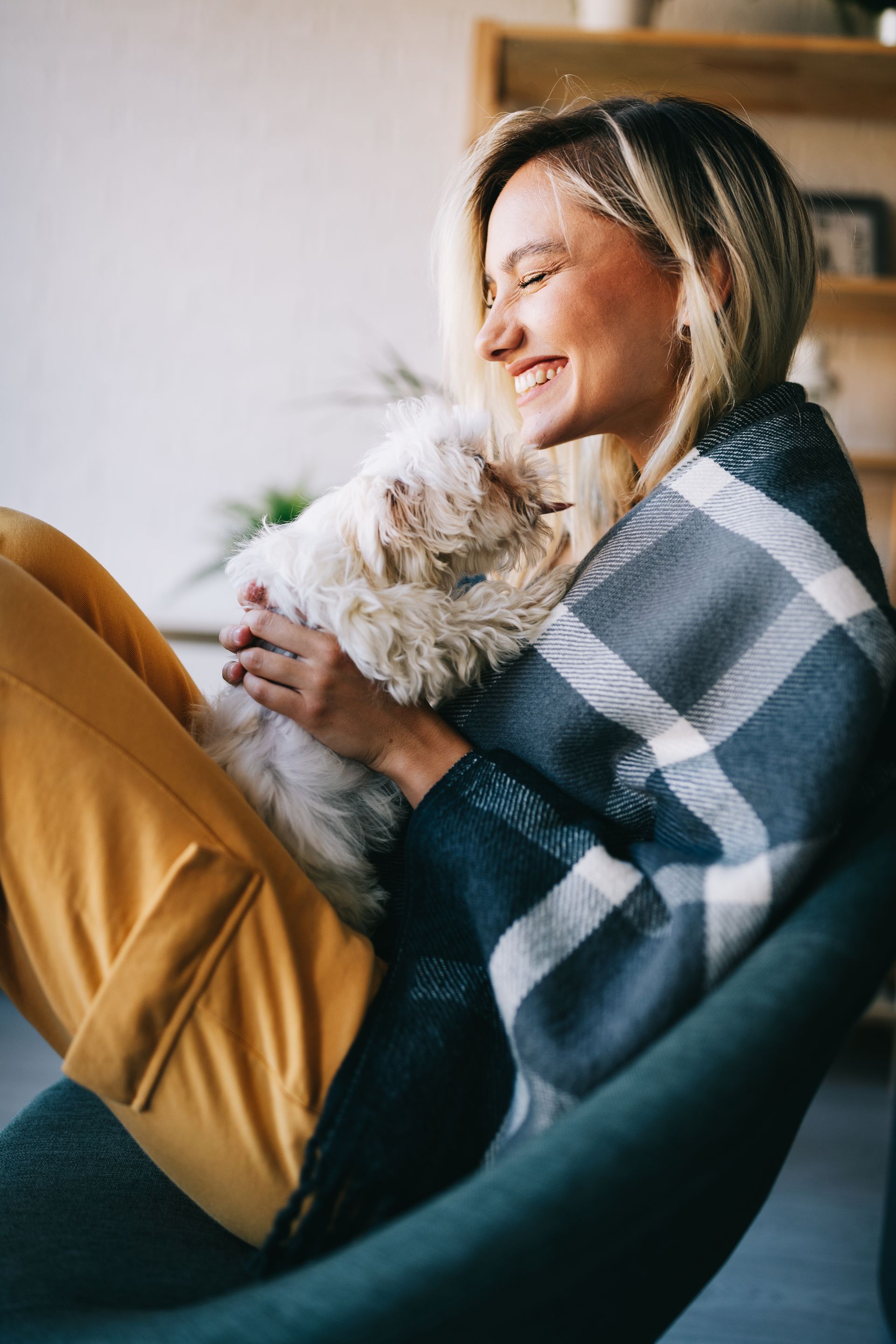 a woman is sitting in a chair holding a dog