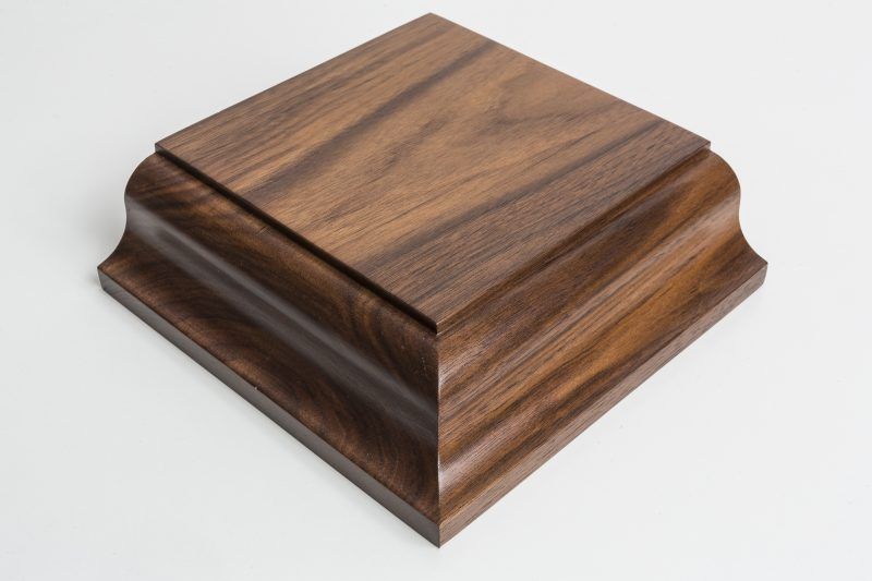 A square wooden box is sitting on a white surface.