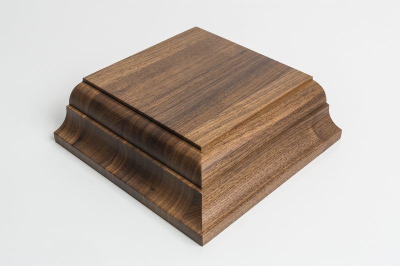 A square wooden box is sitting on a white surface.