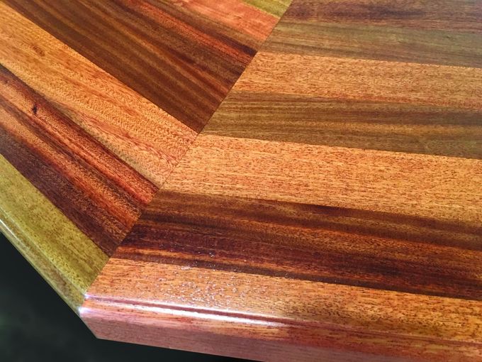 A close up of a wooden table with a chevron pattern.