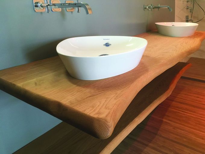 Two sinks on a wooden counter in a bathroom