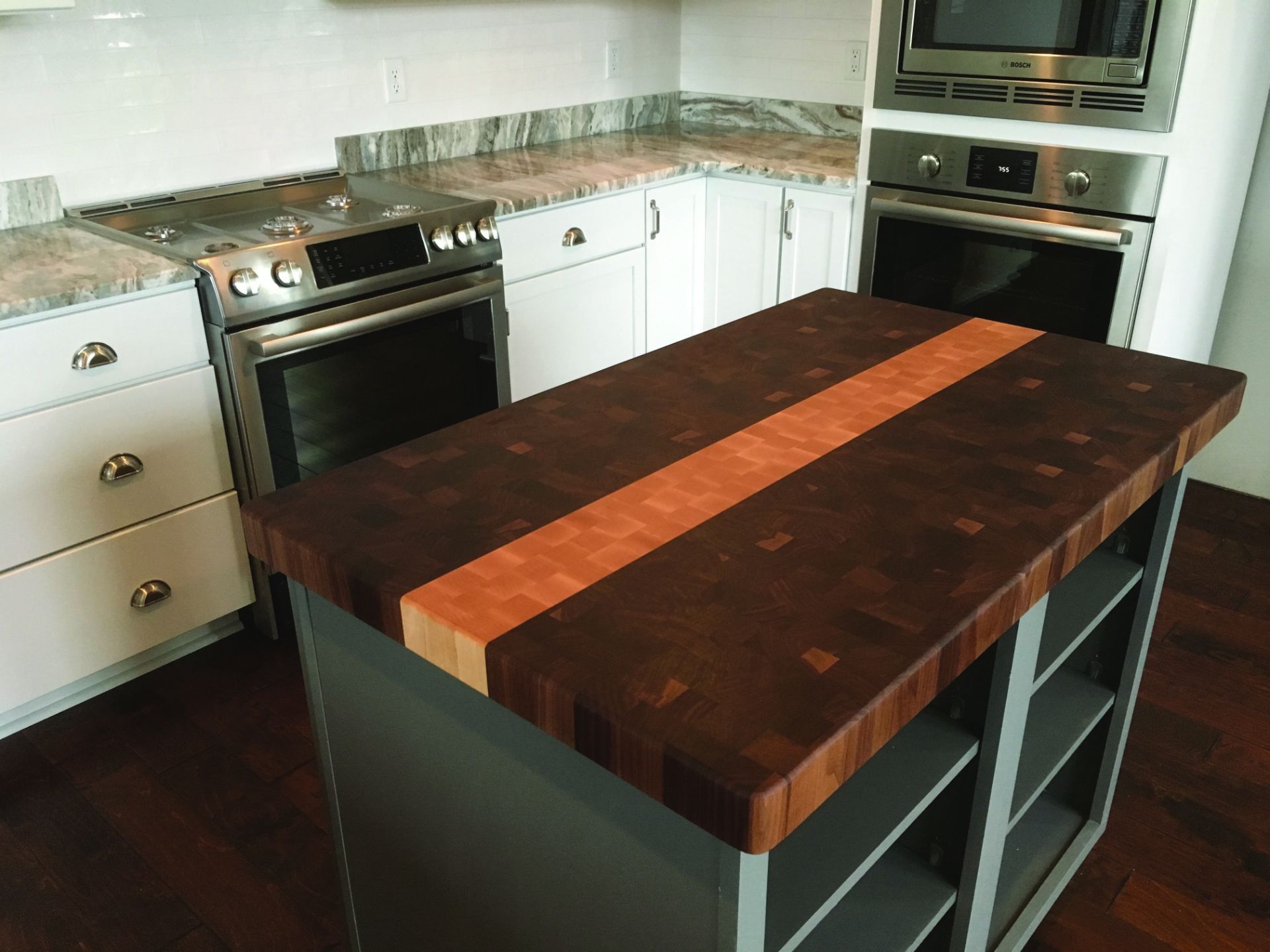 A kitchen with a large wooden island in the middle