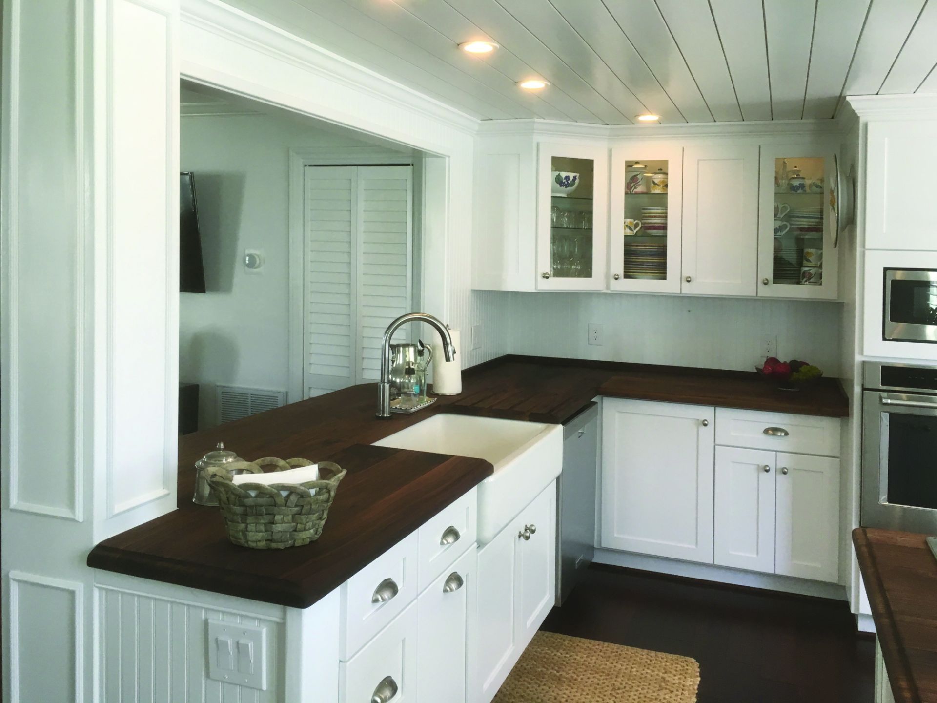 A kitchen with white cabinets and a sink