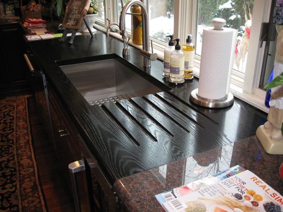 A kitchen counter with a sink and a magazine that says real spa