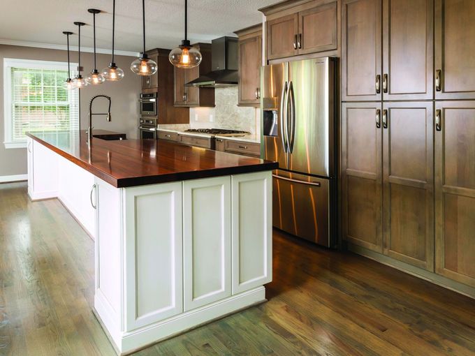 A kitchen with stainless steel appliances , wooden cabinets , and a large island.