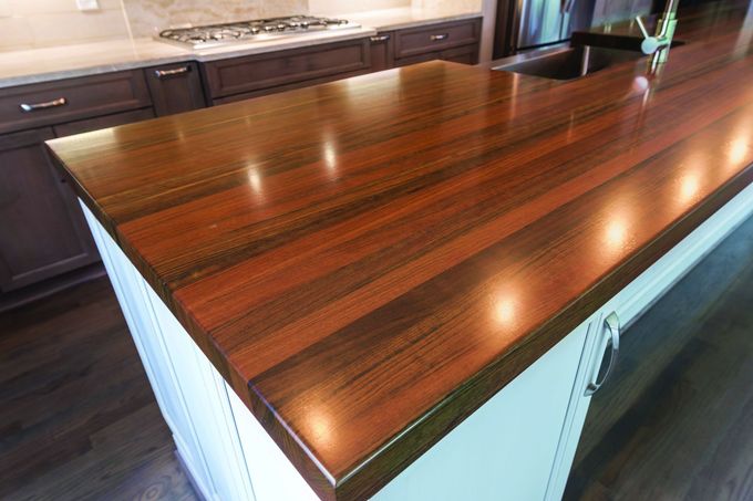 A kitchen island with a wooden counter top and a sink.
