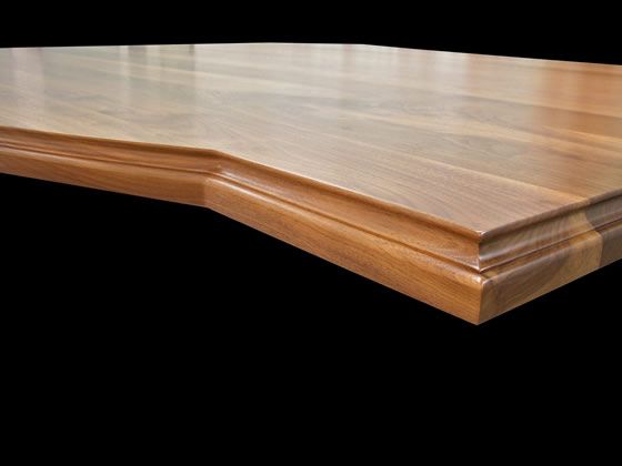 A close up of a wooden table with a black background