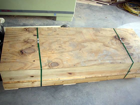 A stack of wooden boards tied together with green string