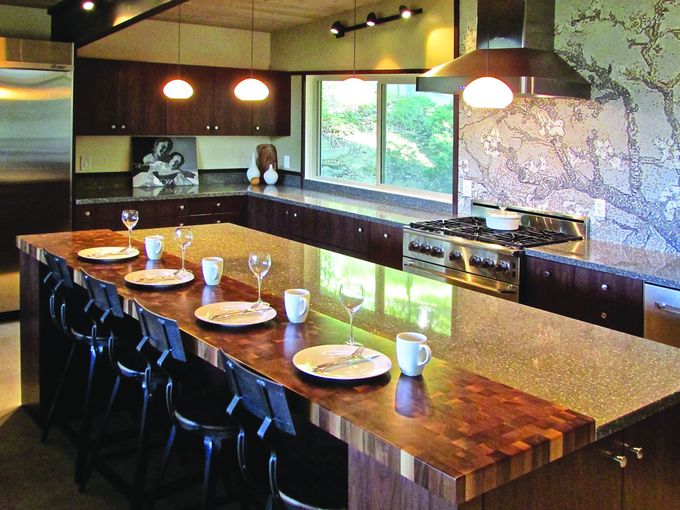 A kitchen with a large island with plates and cups on it