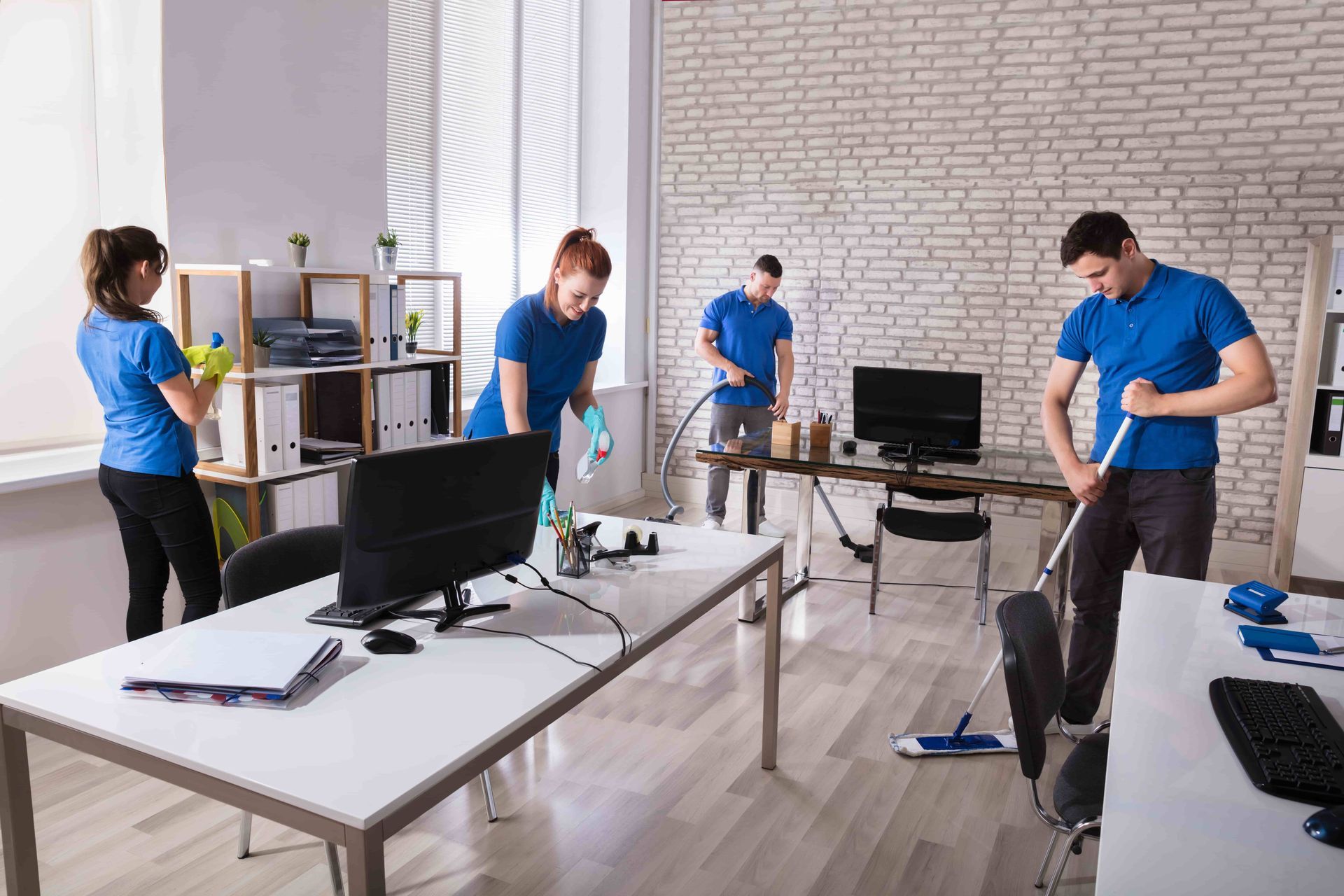 A group of people are cleaning an office.