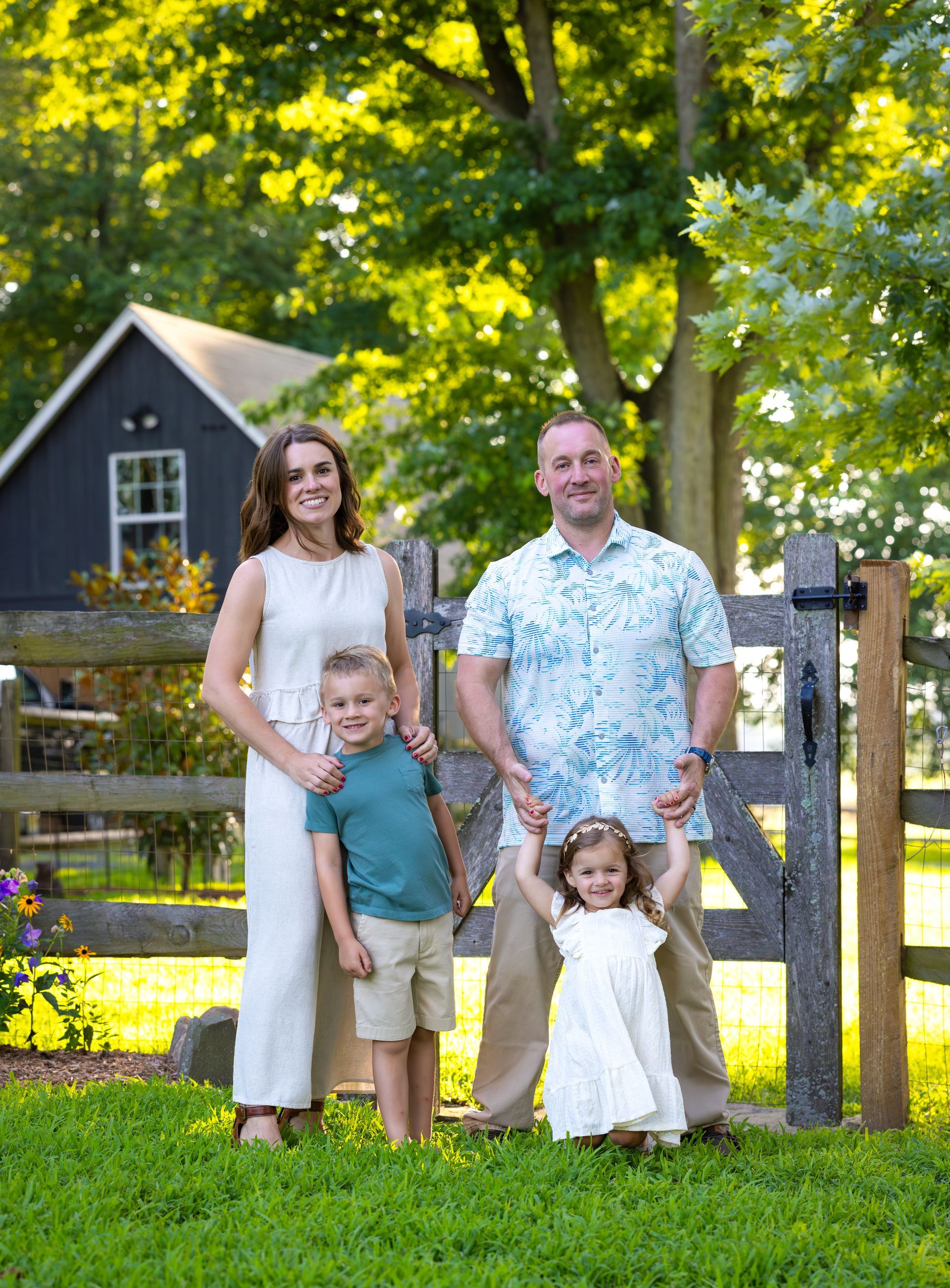 A man in blue overalls is standing in an office with his arms crossed