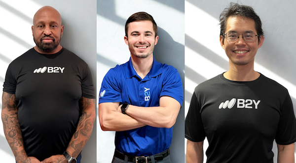 Three people wearing B2Y shirts posing for a photo.