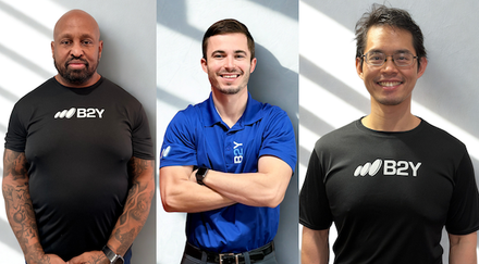 Three people wearing B2Y shirts posing for a photo.