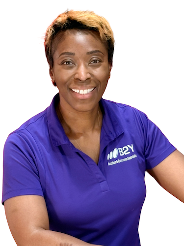 Dr. Natasha Williams smiling, wearing purple polo shirt with logo, indoors.