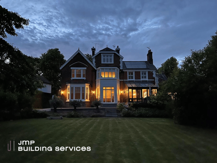 Film crew shooting a scene in a pub. Actors sit at a table; camera crew surrounds them.