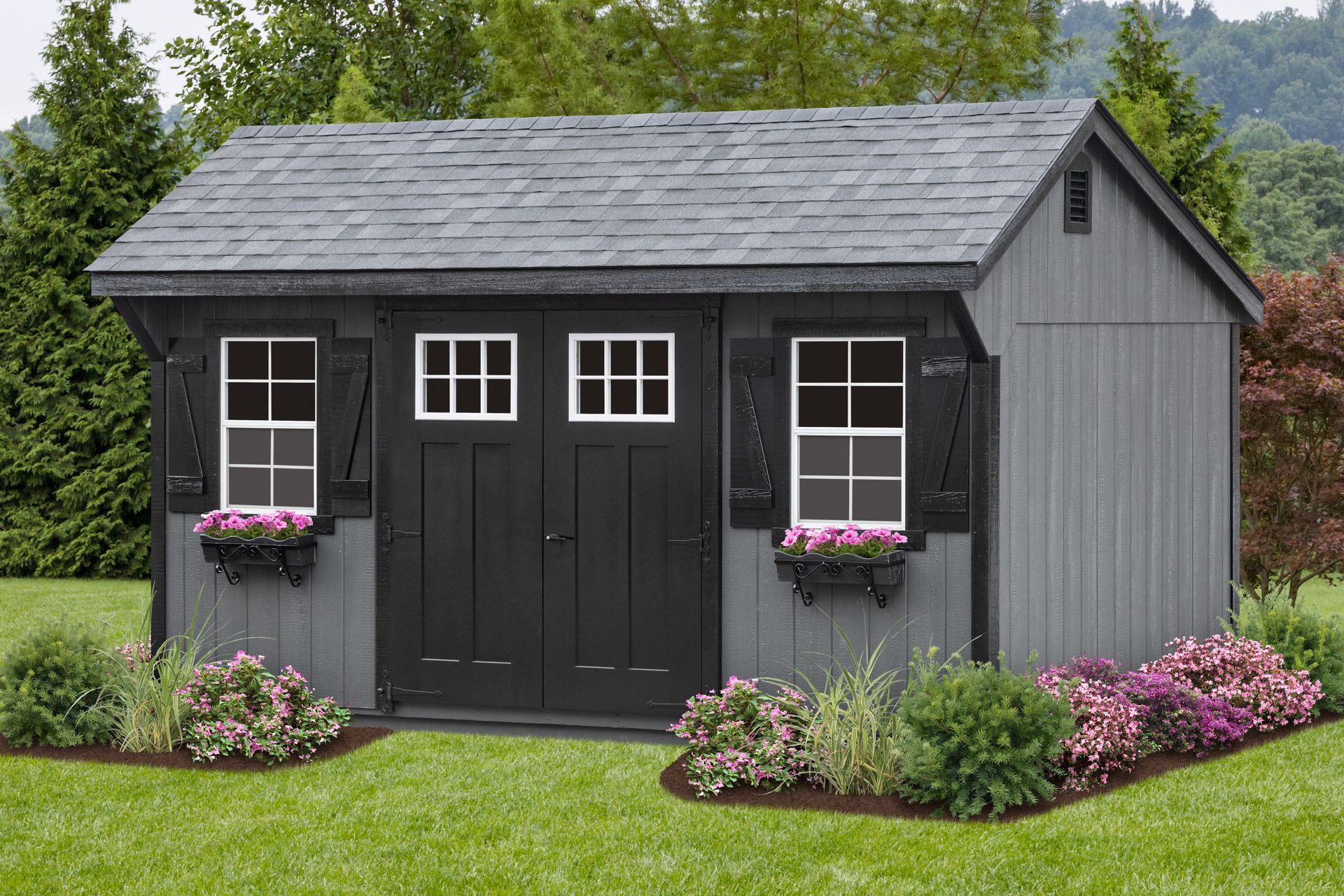 Gray shed with black door, windows, and shutters. Flower boxes and landscaping in front.